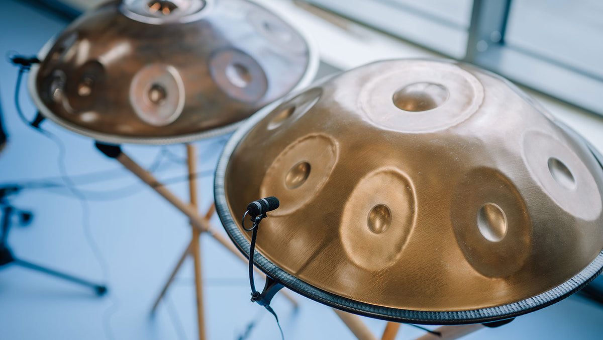 Two microphone-equipped handpans are set side by side for a concert, tuned to A=440 Hz.